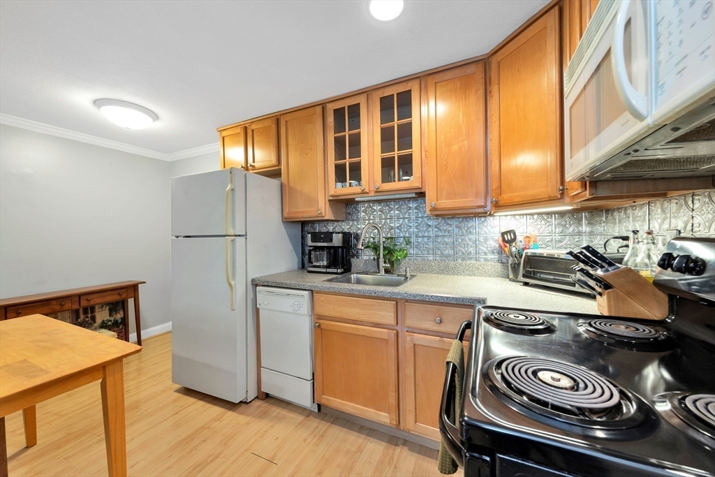 588 Main Street, Unit 3C Stoneham, MA 02180 - Photo 7 of 24 a kitchen with a refrigerator and a stove top oven