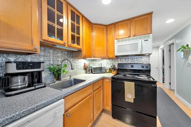 a kitchen with stainless steel appliances granite countertop a stove a sink and a microwave