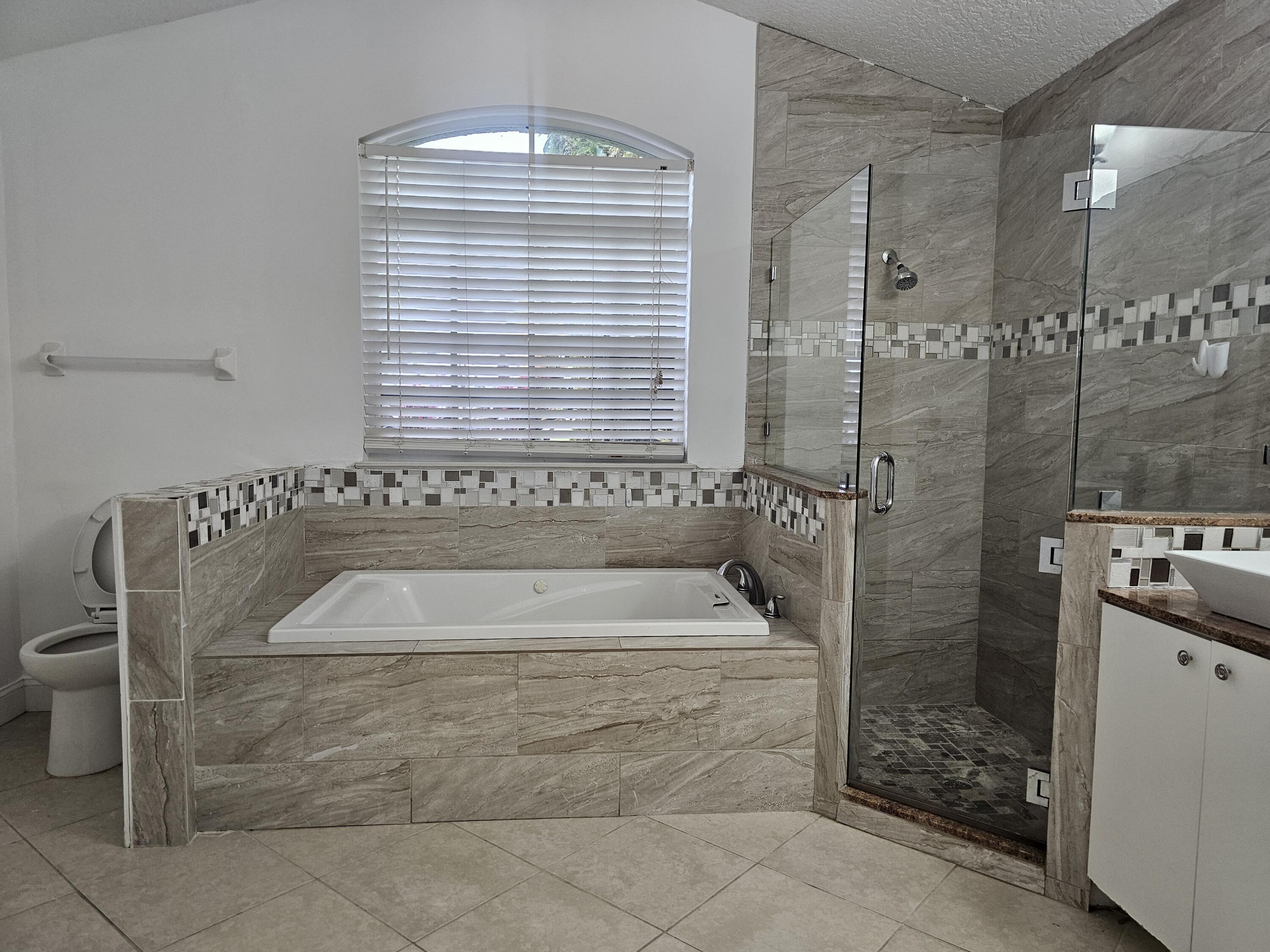 3215 Southeast Pinto Street Port St. Lucie, FL 34984 - Photo 15 of 34 a bathroom with a bathtub and shower