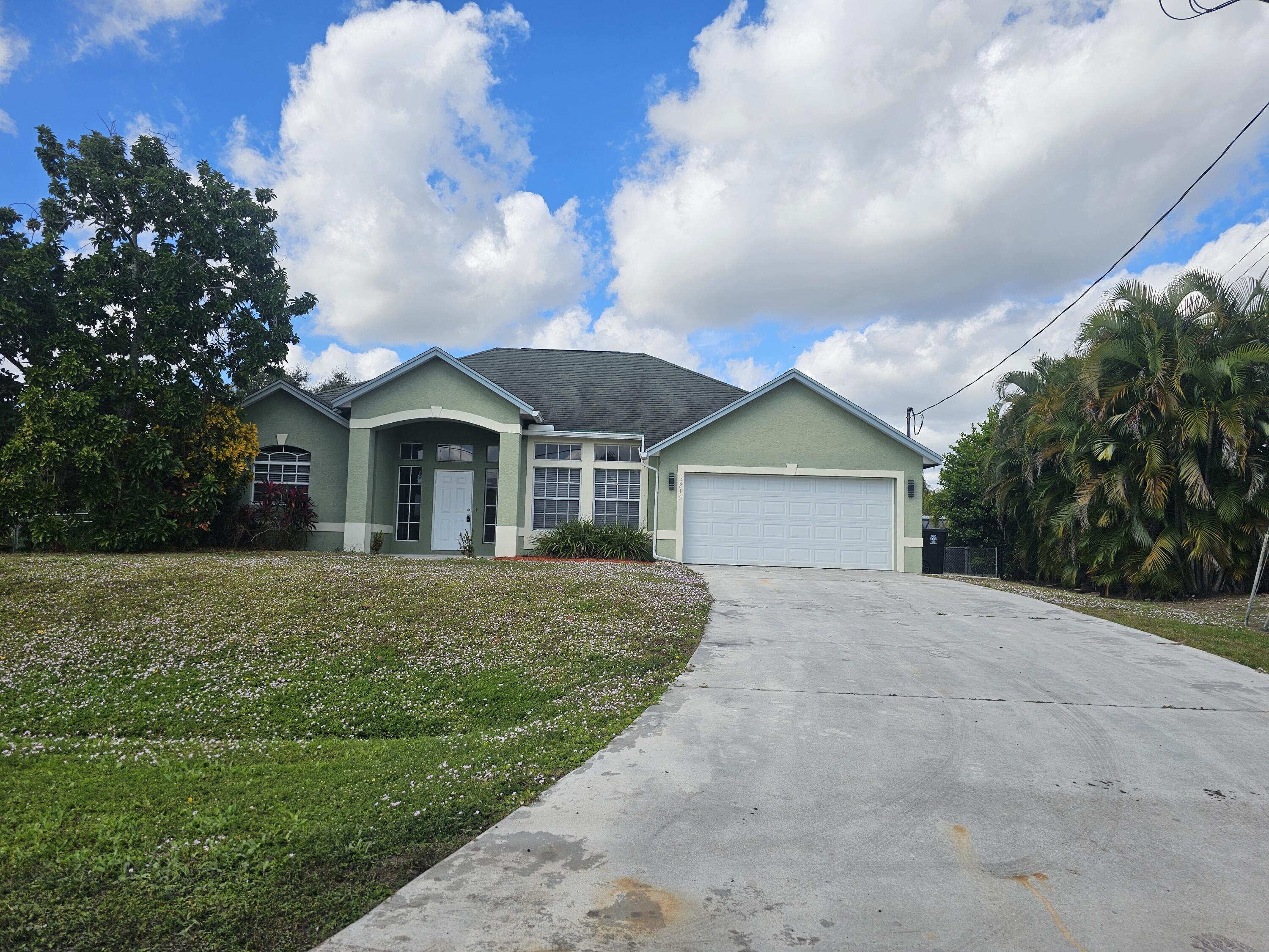 3215 Southeast Pinto Street Port St. Lucie, FL 34984 - Photo 2 of 34 a front view of a house with garden
