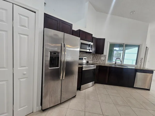 a kitchen with granite countertop a refrigerator and a sink