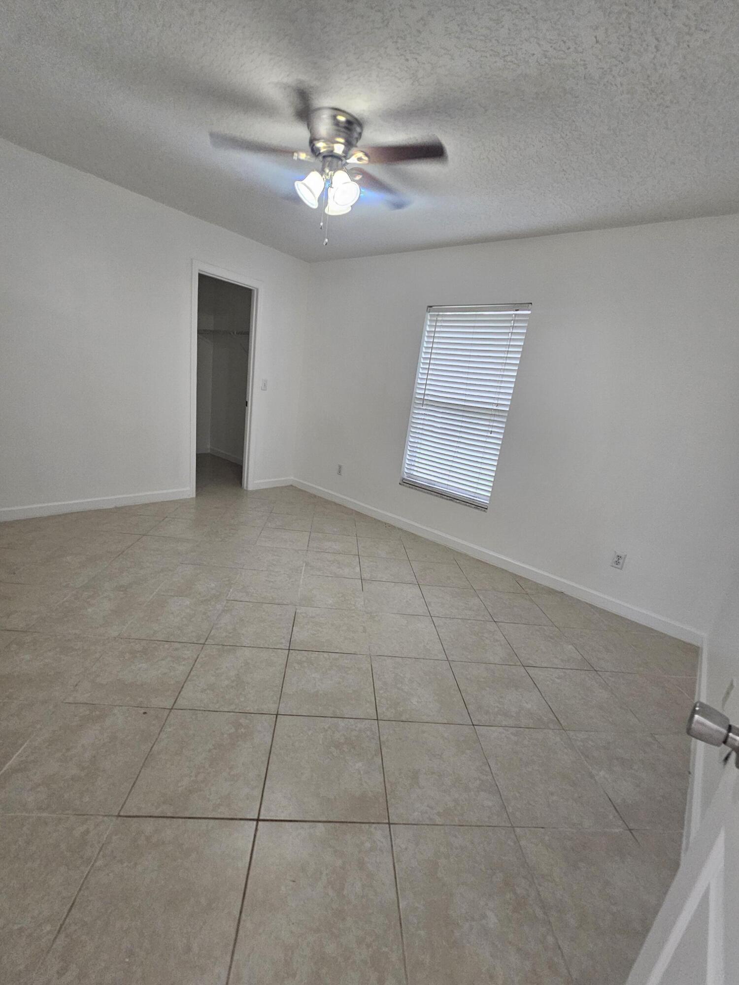 3215 Southeast Pinto Street Port St. Lucie, FL 34984 - Photo 25 of 34 a view of an empty room with a chandelier fan