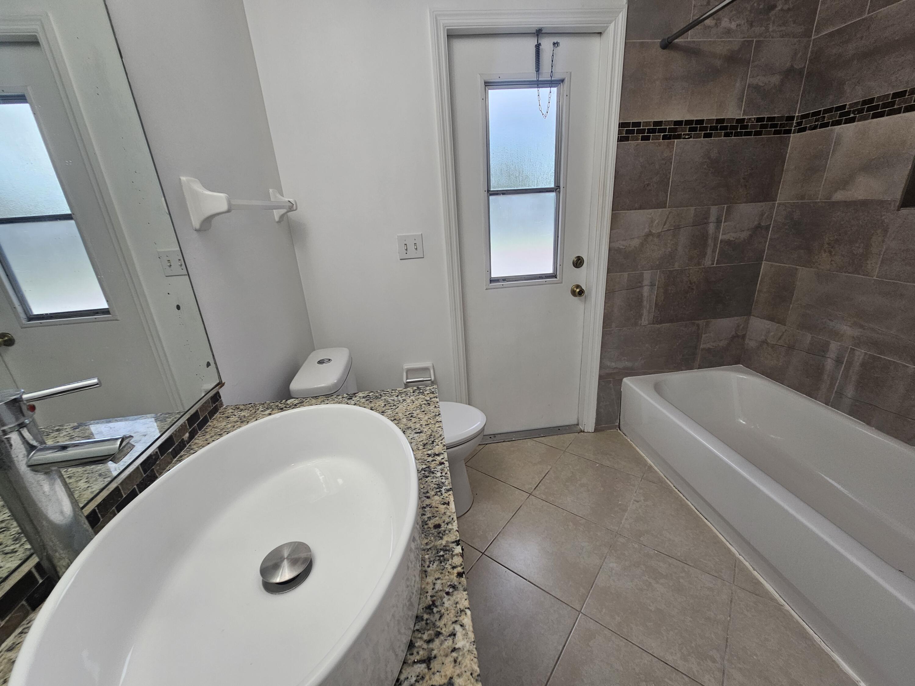 3215 Southeast Pinto Street Port St. Lucie, FL 34984 - Photo 27 of 34 a bathroom with a tub a sink and a shower