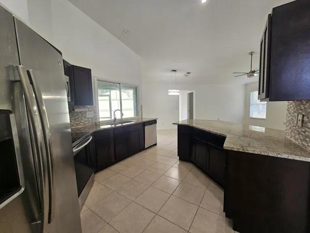 a kitchen with granite countertop a refrigerator and a sink