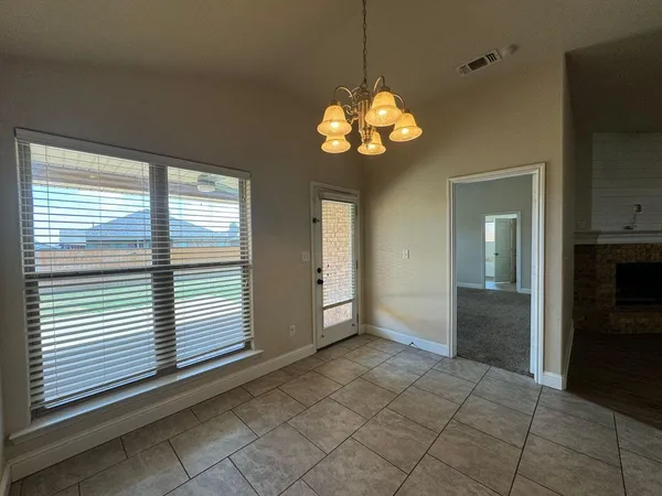 a view of a room with a large window a chandelier and stairs