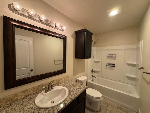 a bathroom with a sink toilet double vanity and tub