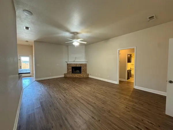 an empty room with wooden floor and a fireplace