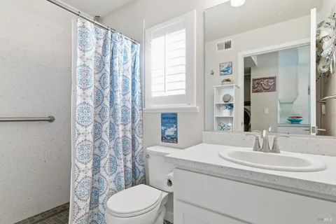 a bathroom with a sink a toilet and shower curtain