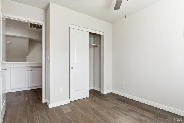 an empty room with wooden floor and closet