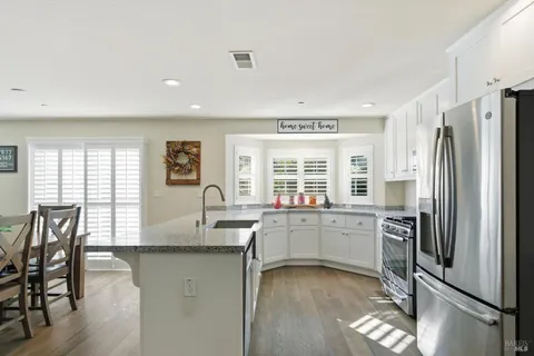 a kitchen with stainless steel appliances granite countertop a refrigerator and a stove top oven