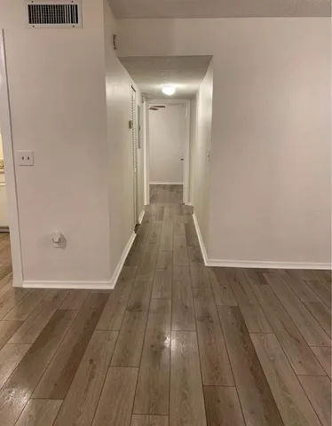 a view of a hallway with wooden floor