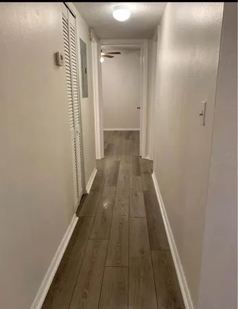a view of a hallway with wooden floor