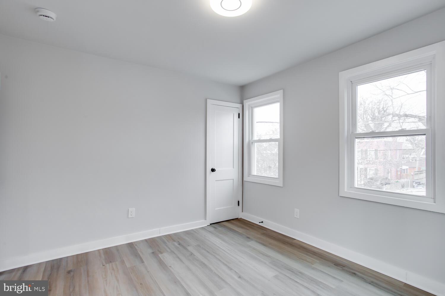 4803 Bass Place Southeast Washington, DC 20019 - Photo 11 of 22 an empty room with wooden floor and windows