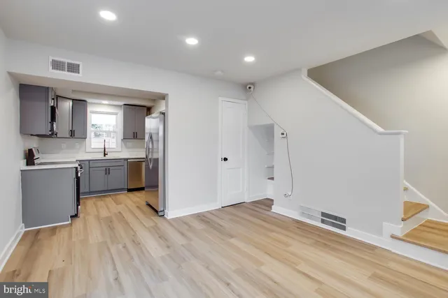 a view of a kitchen with a sink and dishwasher with wooden floor