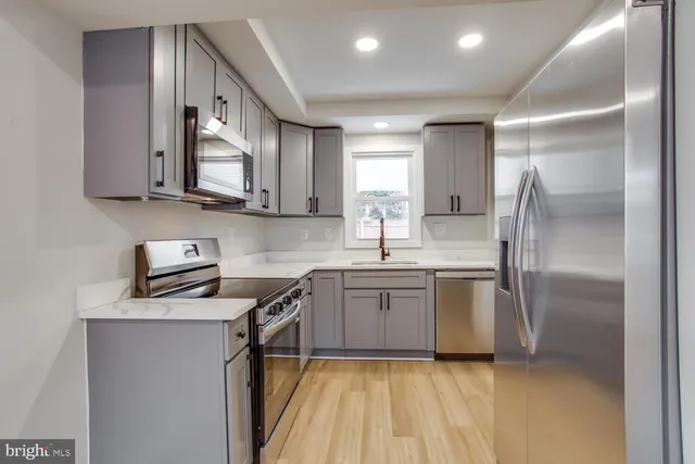 a kitchen with stainless steel appliances granite countertop a refrigerator sink and stove