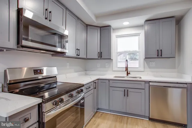 a kitchen with cabinets appliances and a sink