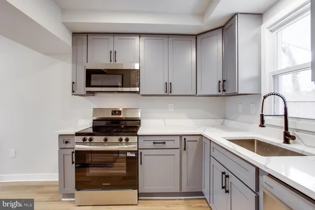 a kitchen with cabinets stainless steel appliances and a sink