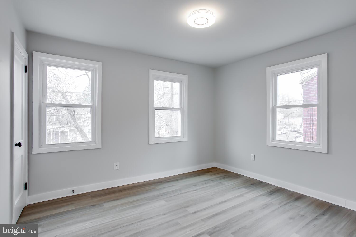 4803 Bass Place Southeast Washington, DC 20019 - Photo 10 of 22 an empty room with wooden floor and windows