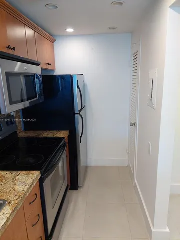 a kitchen with a refrigerator and a stove top oven