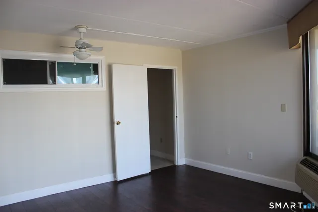 a view of an empty room with wooden floor