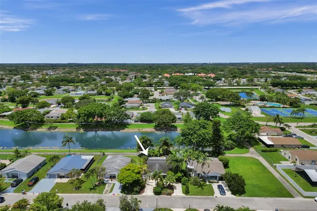 an aerial view of a house with a garden and lake view