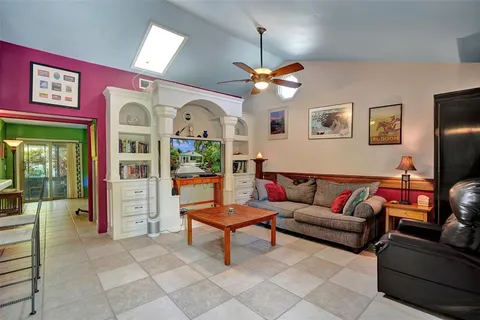 a living room with furniture a ceiling fan and a window