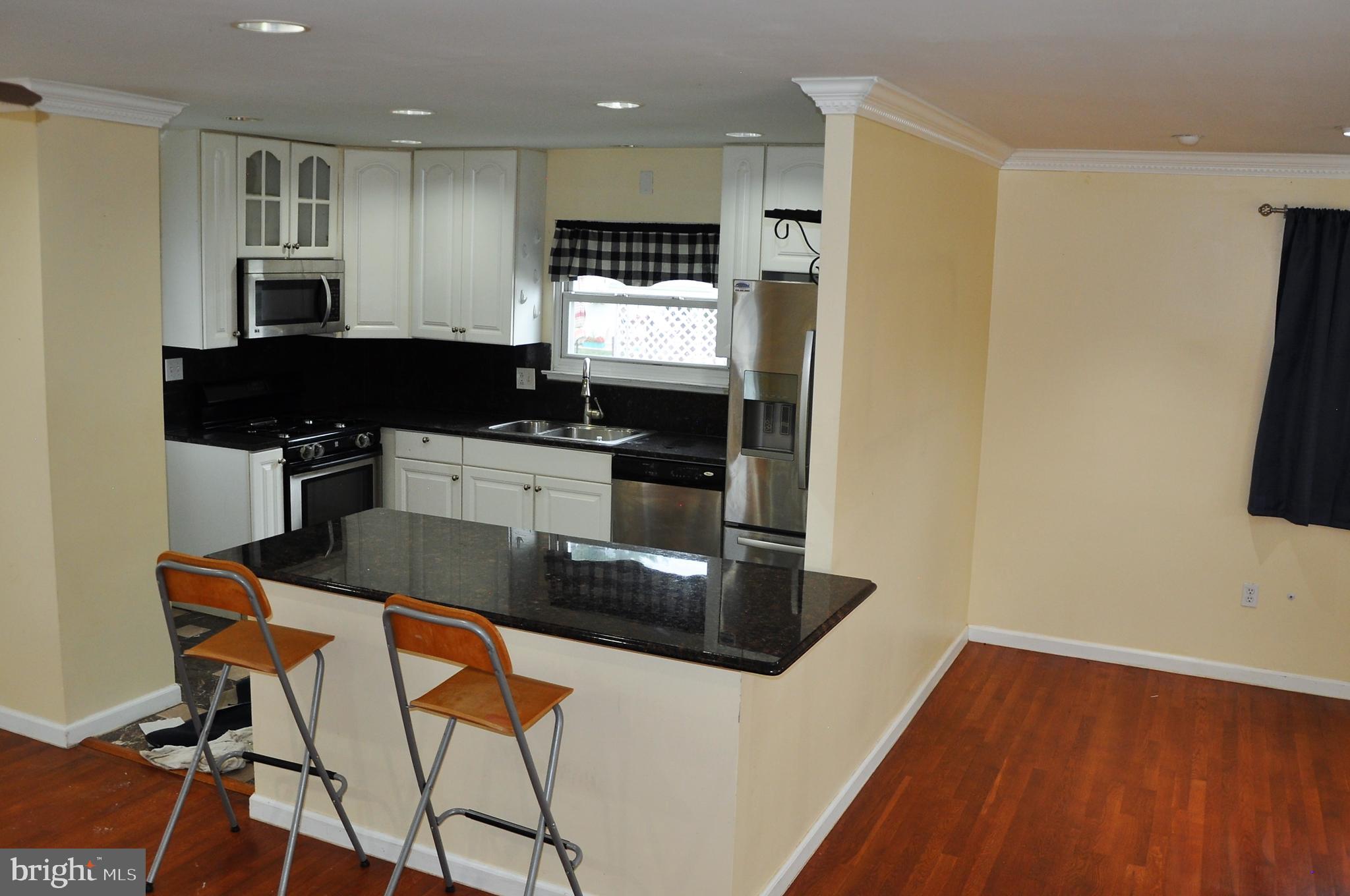 705 Crosby Road Baltimore, MD 21228 - Photo 12 of 37 a kitchen with stainless steel appliances a microwave a sink and white cabinets