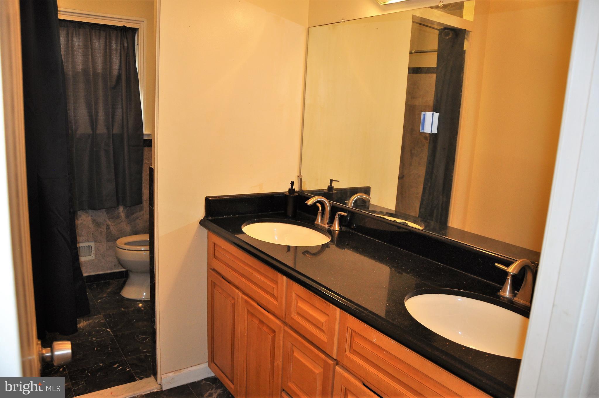 705 Crosby Road Baltimore, MD 21228 - Photo 13 of 37 a bathroom with a granite countertop sink and a mirror