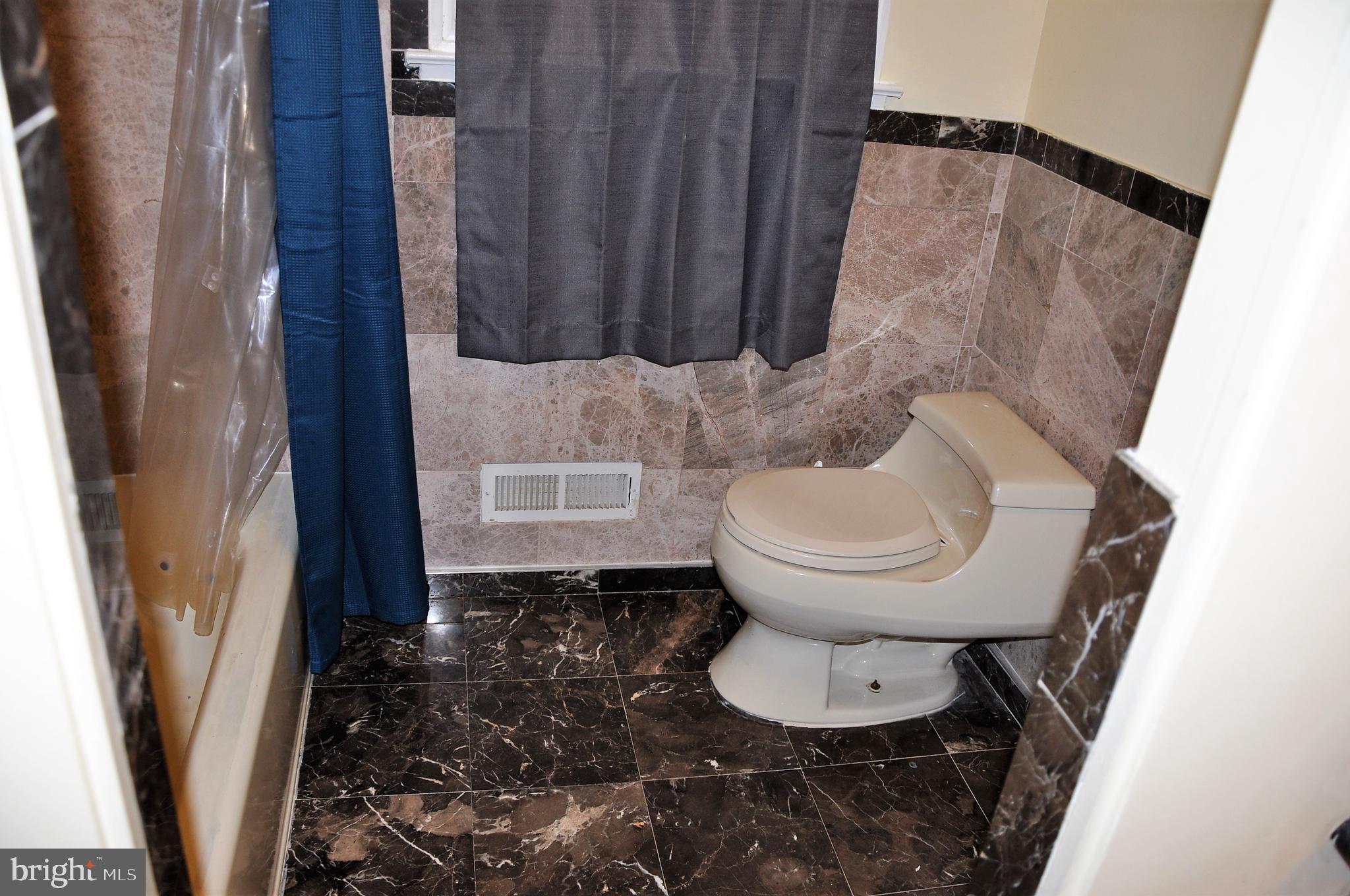705 Crosby Road Baltimore, MD 21228 - Photo 15 of 37 a bathroom with a toilet and a shower