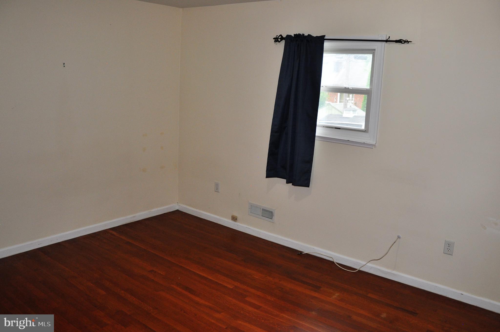 705 Crosby Road Baltimore, MD 21228 - Photo 17 of 37 a view of an empty room with wooden floor and a window