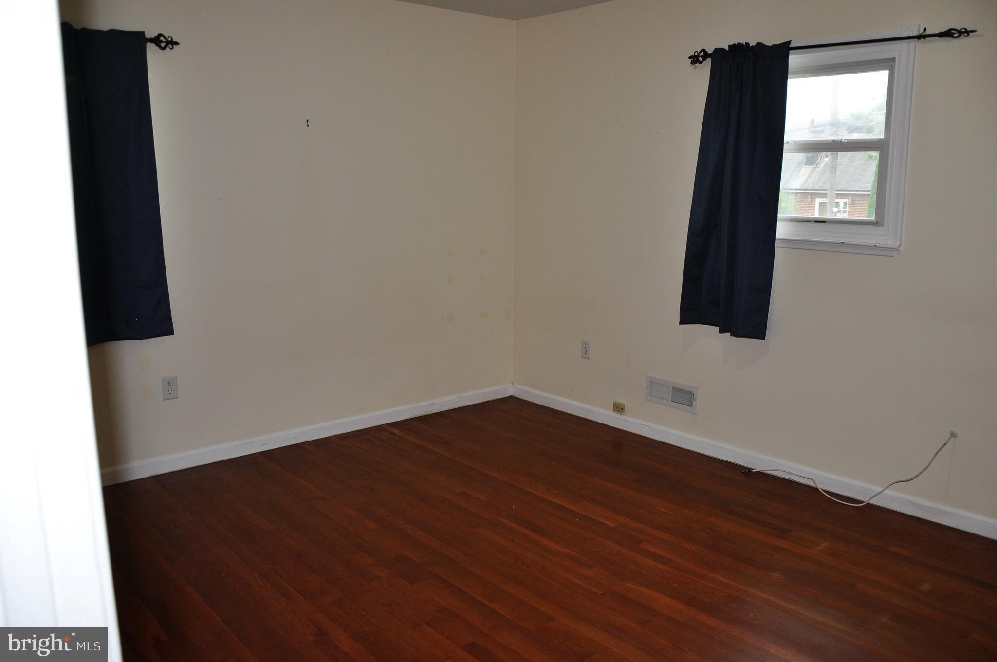 705 Crosby Road Baltimore, MD 21228 - Photo 18 of 37 an empty room with wooden floor and windows