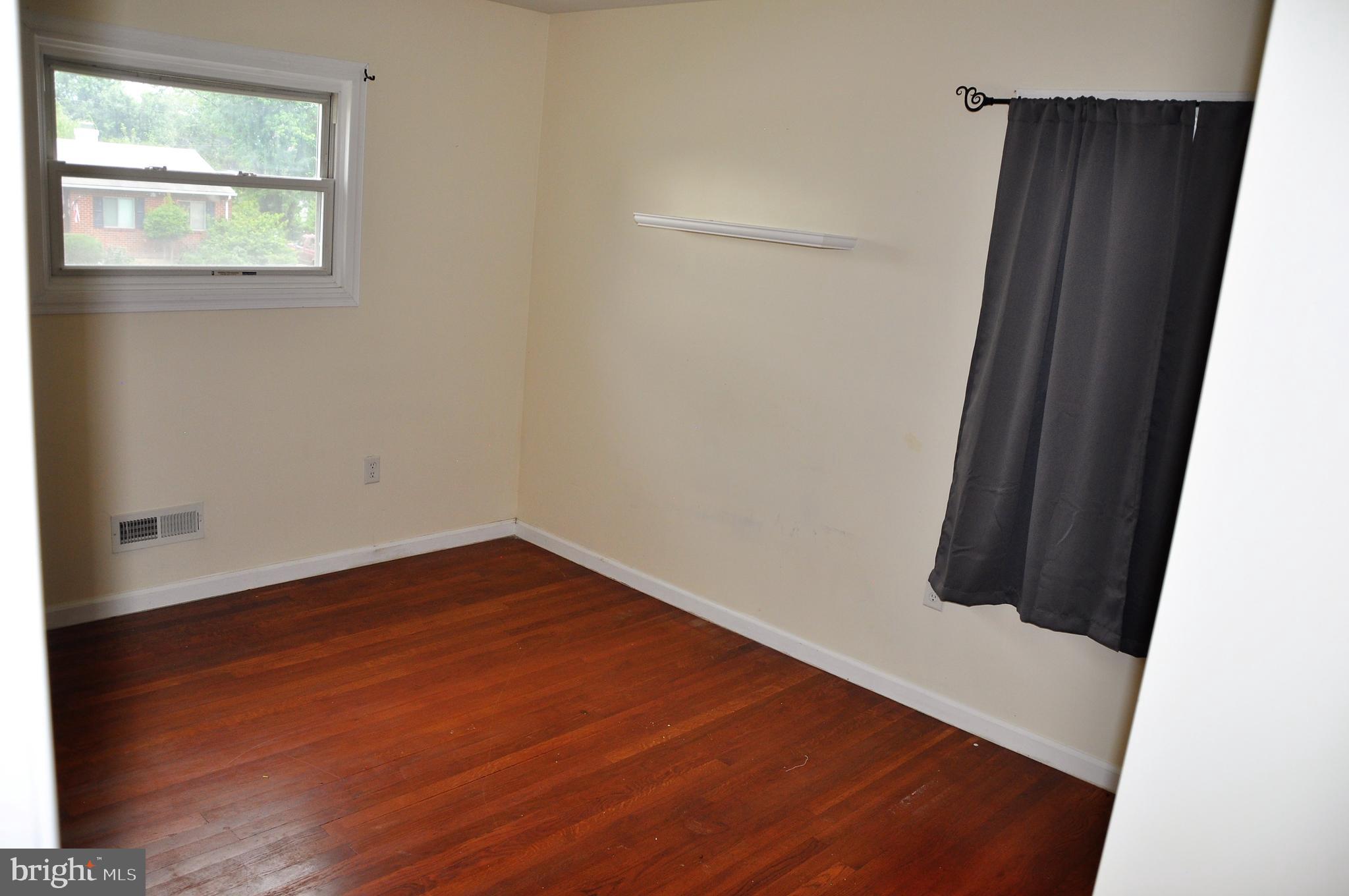 705 Crosby Road Baltimore, MD 21228 - Photo 19 of 37 an empty room with wooden floor and windows