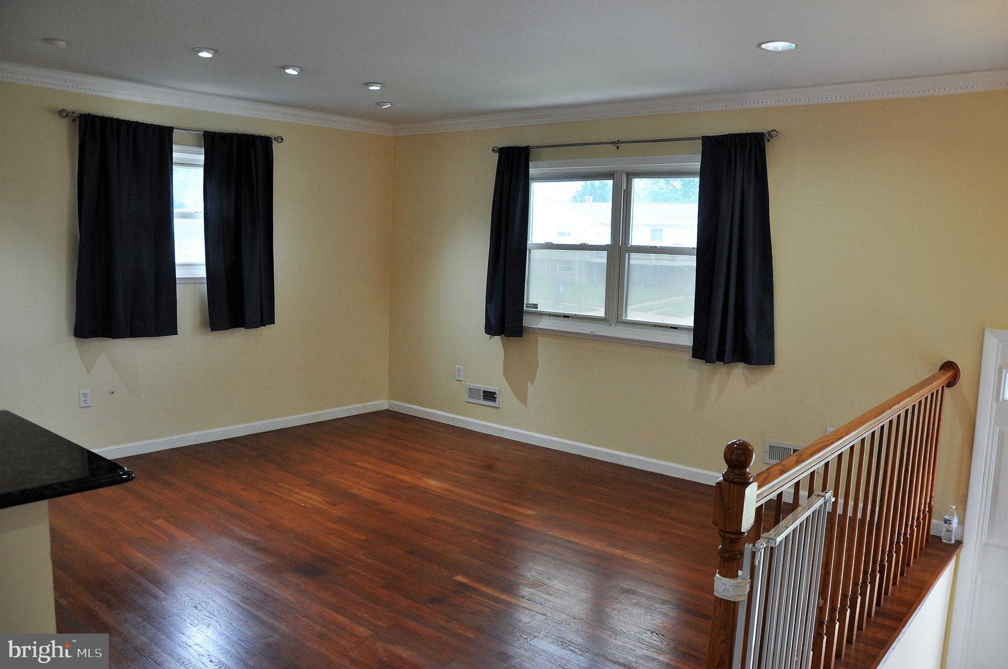 705 Crosby Road Baltimore, MD 21228 - Photo 3 of 37 a view of an empty room with wooden floor and a window