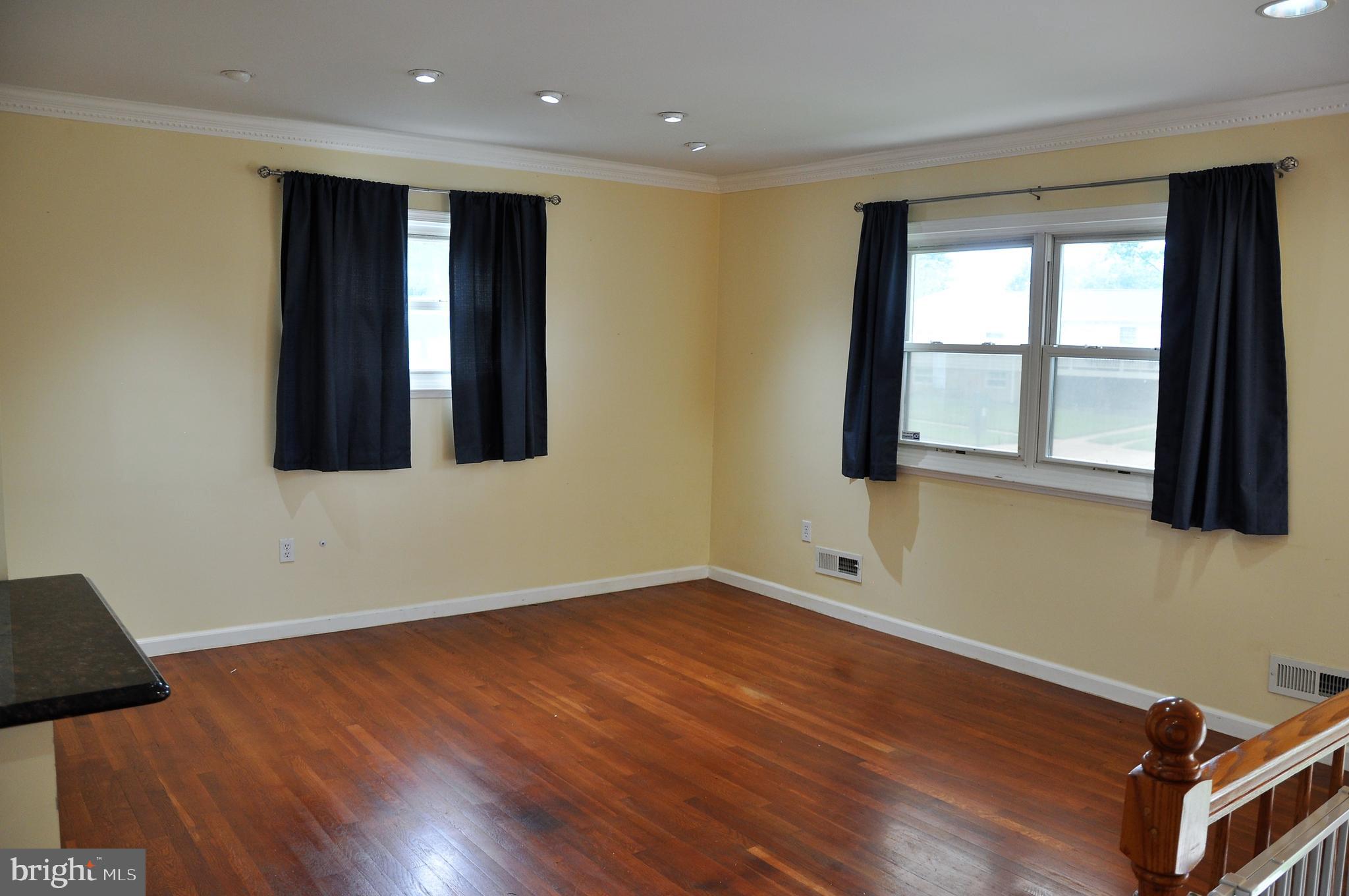 705 Crosby Road Baltimore, MD 21228 - Photo 4 of 37 a view of an empty room with wooden floor and a window