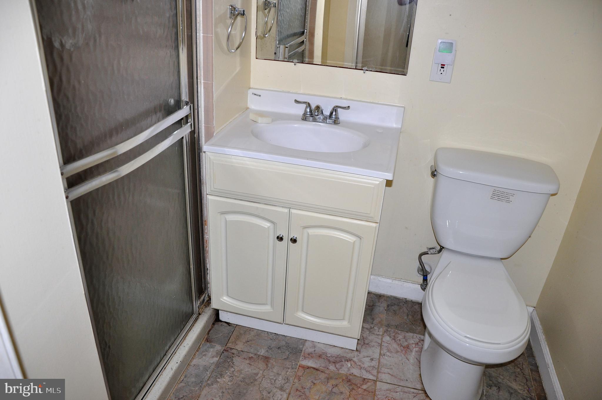 705 Crosby Road Baltimore, MD 21228 - Photo 33 of 37 a bathroom with a toilet sink and a mirror