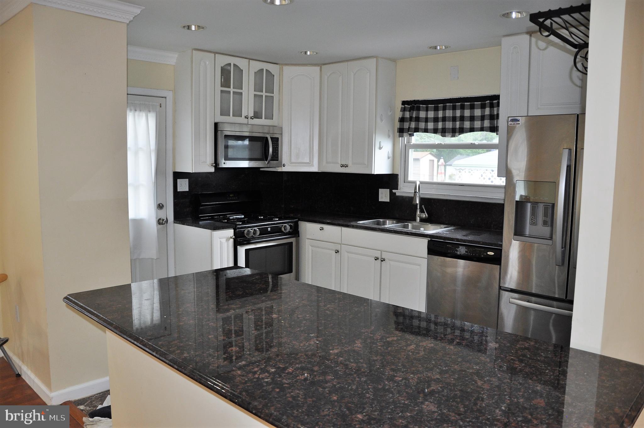 705 Crosby Road Baltimore, MD 21228 - Photo 5 of 37 a kitchen with stainless steel appliances granite countertop a sink stove and refrigerator