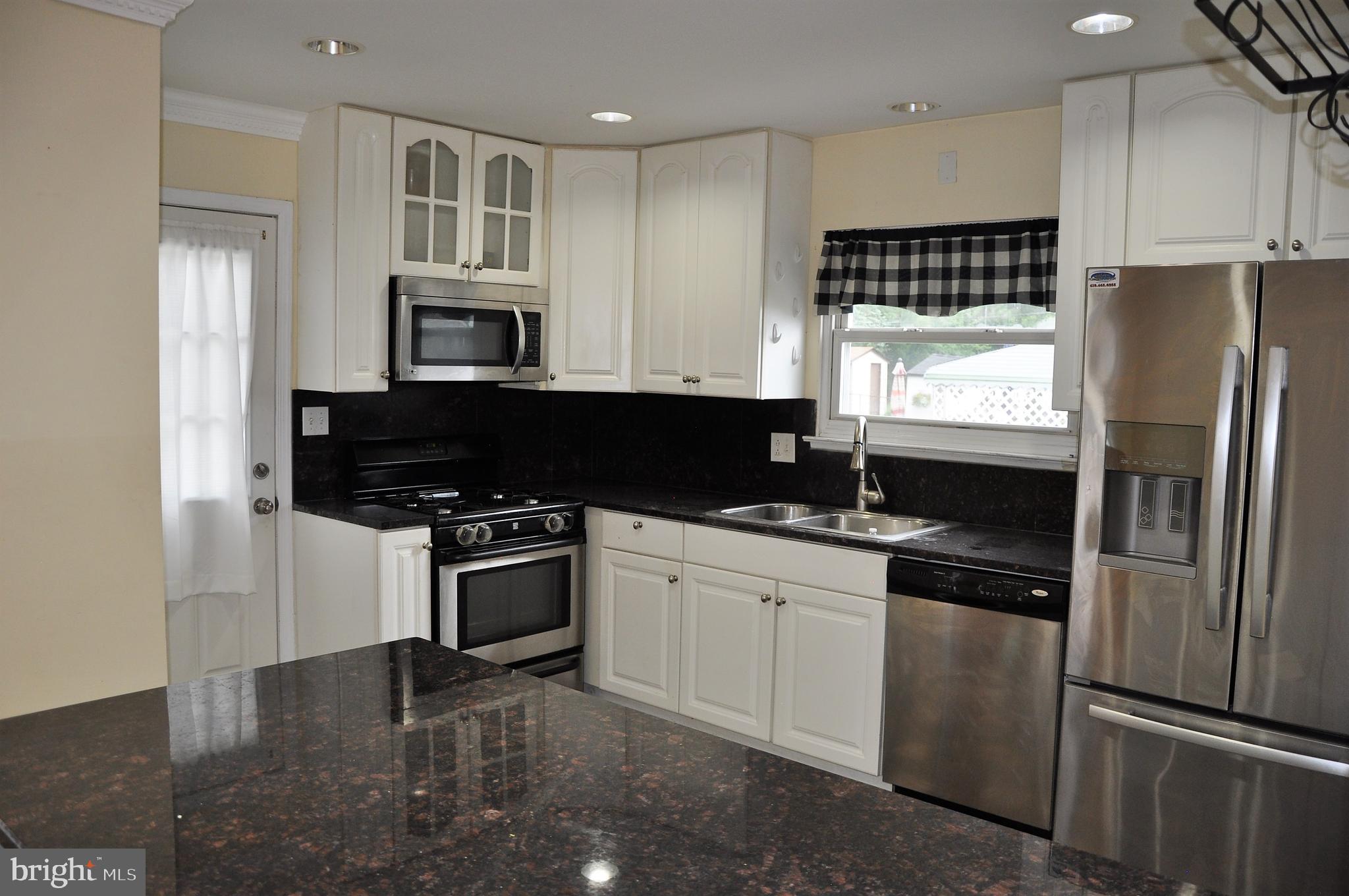 705 Crosby Road Baltimore, MD 21228 - Photo 6 of 37 a kitchen with granite countertop a refrigerator stove top oven and sink