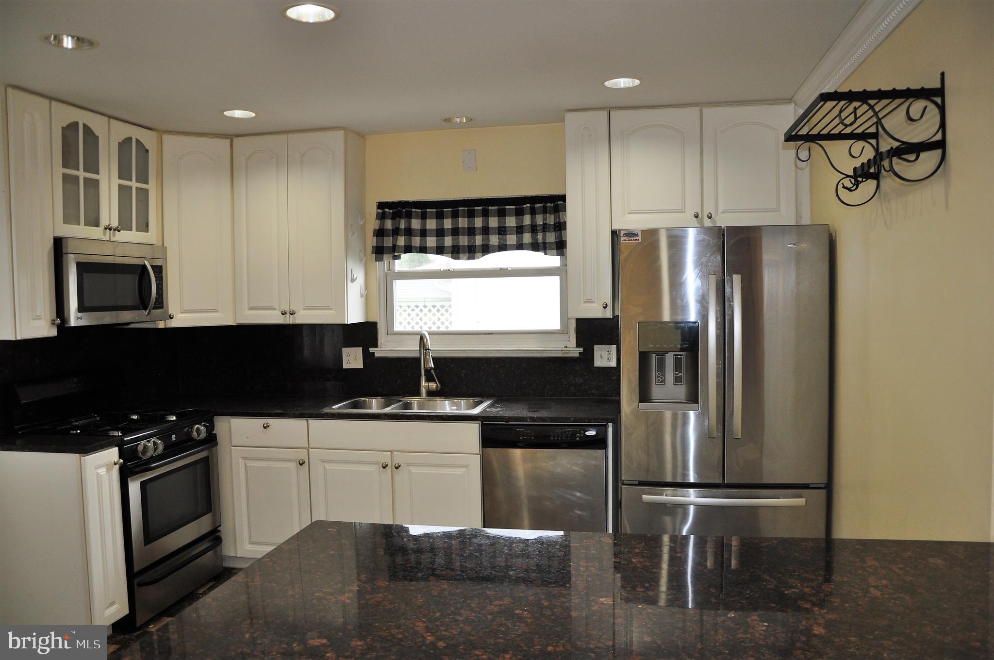 705 Crosby Road Baltimore, MD 21228 - Photo 7 of 37 a kitchen with granite countertop a refrigerator stove top oven and sink