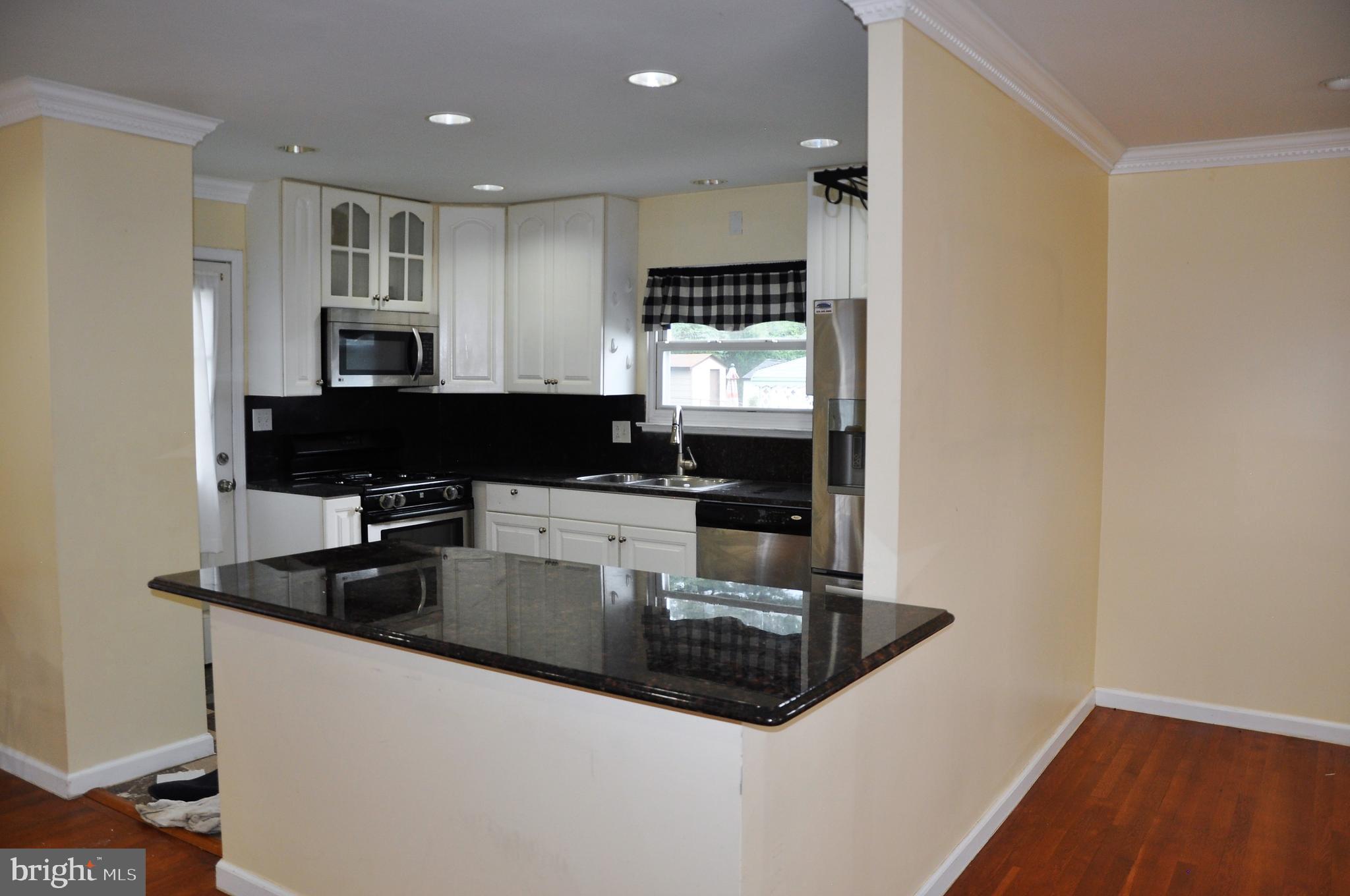 705 Crosby Road Baltimore, MD 21228 - Photo 8 of 37 a kitchen with stainless steel appliances granite countertop a sink and a refrigerator
