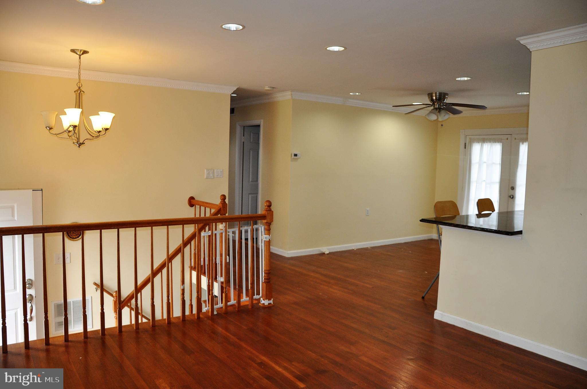 705 Crosby Road Baltimore, MD 21228 - Photo 10 of 37 a view of a hallway with wooden floor and a chandelier