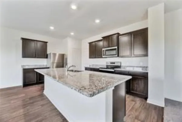 a kitchen with stainless steel appliances granite countertop a sink and a microwave
