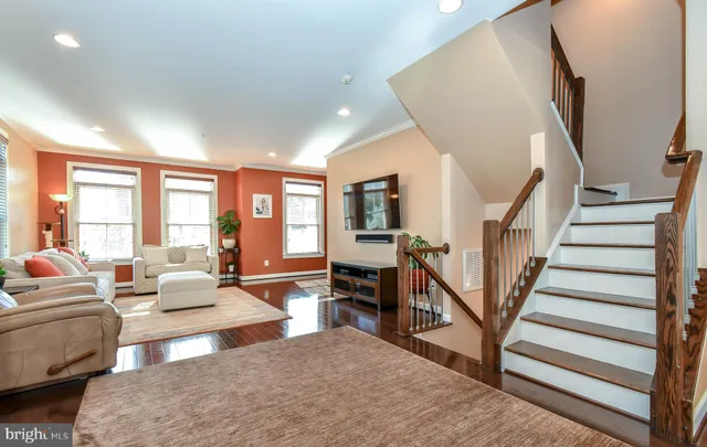 a living room with furniture wooden floor and a flat screen tv
