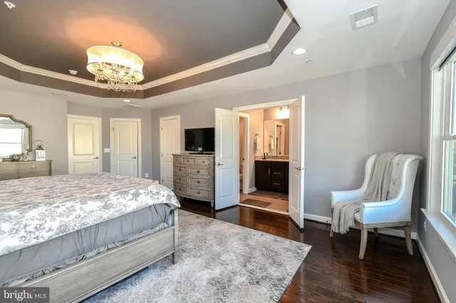 a spacious bedroom with a bed and a chandelier