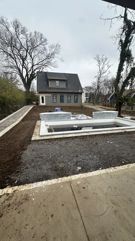 a view of house with outdoor space and trees