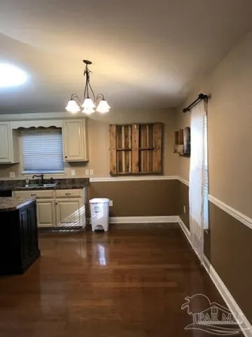 a kitchen with kitchen island granite countertop a stove and a wooden floor