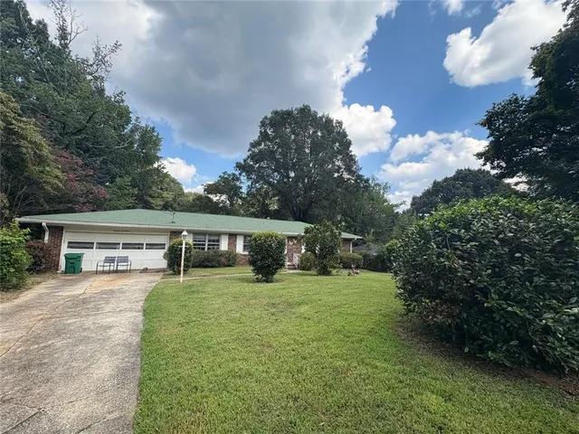 a view of a house with a yard and sitting area
