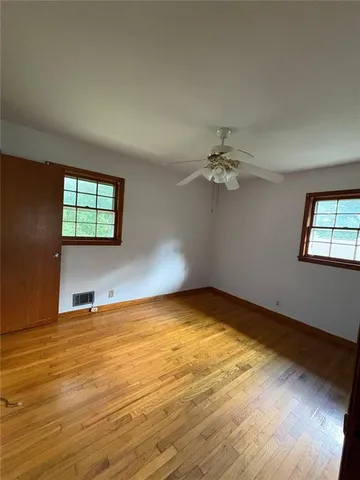 wooden floor in an empty room with a window