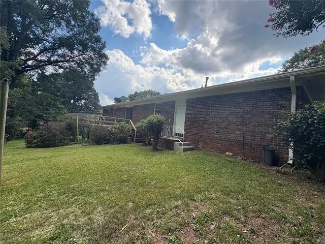 a view of a backyard with potted plants and a large tree