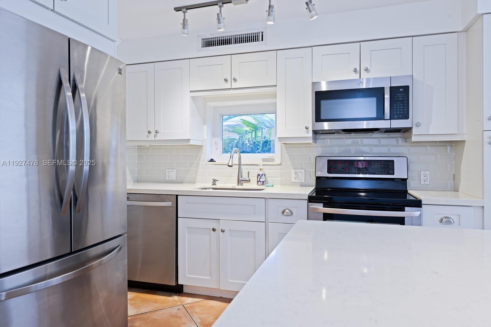 3028 Center Street, Unit 3028 Miami, FL 33133 - Photo 10 of 24 a kitchen with stainless steel appliances a stove a sink and a refrigerator