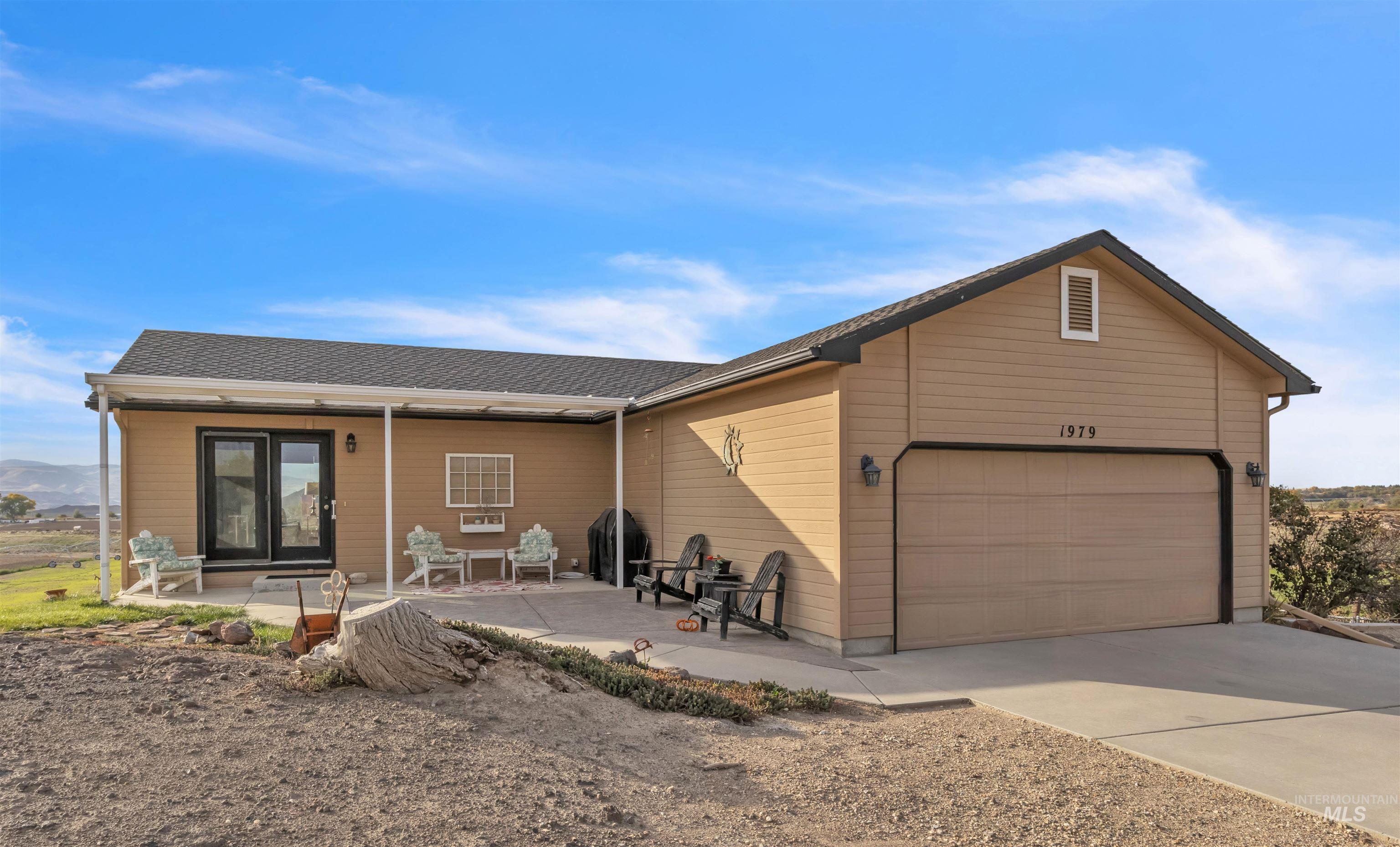 1979 South Can Ada Road Melba, ID 83641 - Photo 2 of 33 Ranch-style house with a garage, driveway, a shingled roof, and a patio area